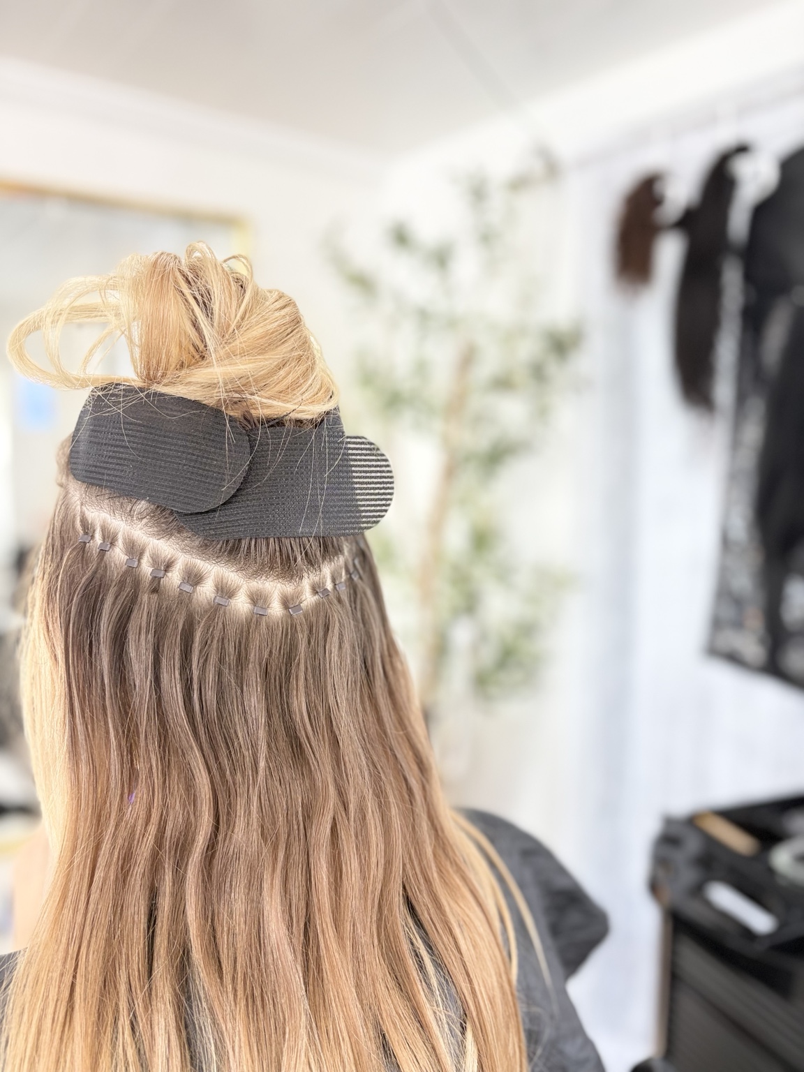 Close-up of beads placed along a sectioned row of blonde hair